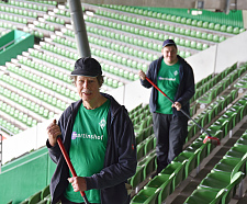 Zwei Menschen reinigen Sitzplätze im Weserstadion