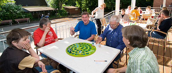 Eine Gruppe spielt ein Brettspiel.