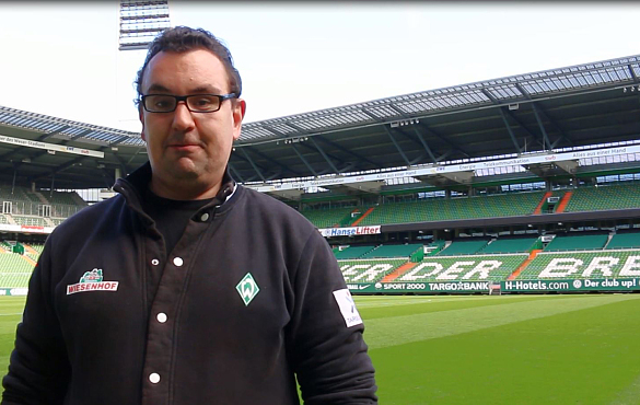 Ein Mann steht im leeren Weser-Stadion zur Kamera gewandt.
